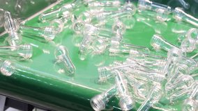 Plastic bottle preforms. Making of Transparent PET plastic preforms move along automated conveyor belt in factory. Industrial production line concept for plastic bottle packaging automation recycling - Powered by Shutterstock - Get 15% off with code: PIKWIZARD15