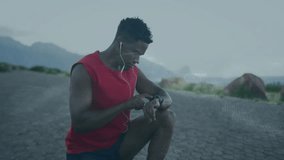 athletic man kneeling on coastal walkway, tapping smartwatch with floating technology data overlay. Tech, fitness, modern, outdoor, active, performance, digital - Powered by Shutterstock - Get 15% off with code: PIKWIZARD15