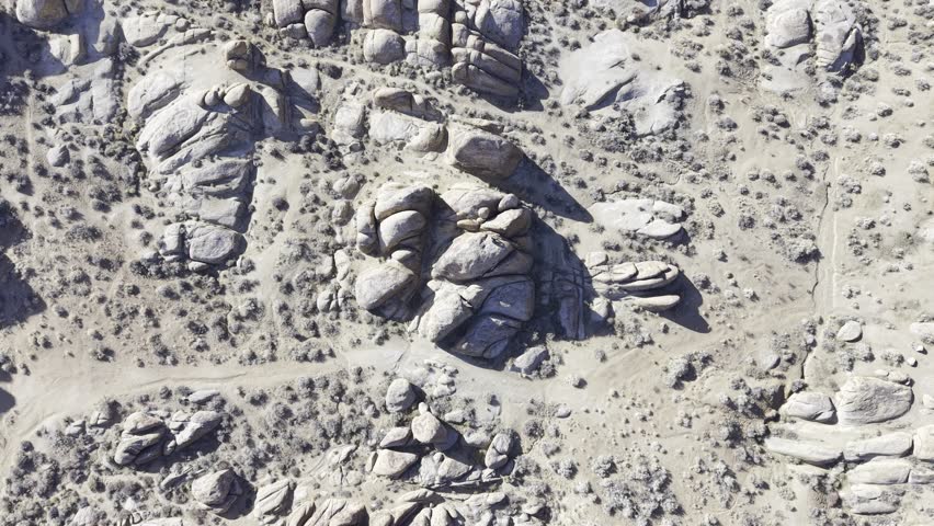 A horizontal 4K drone descending over the boulders and natural landscape of Alabama Hills, California, capturing rugged rock formations, desert terrain, and scenic outdoor adventure in real time