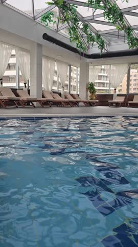 Empty indoors swimming pool with blu water during wintertime