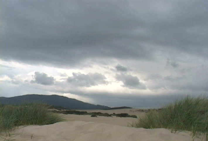 Man walks away on sand dune.