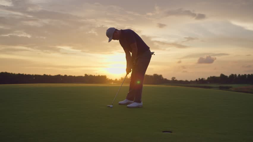 Professional young male golfer swings his club on scenic golf course. Attractive sportsman enjoy outdoor recreation with light exercise and sport lifestyle while playing golf at course grounds.