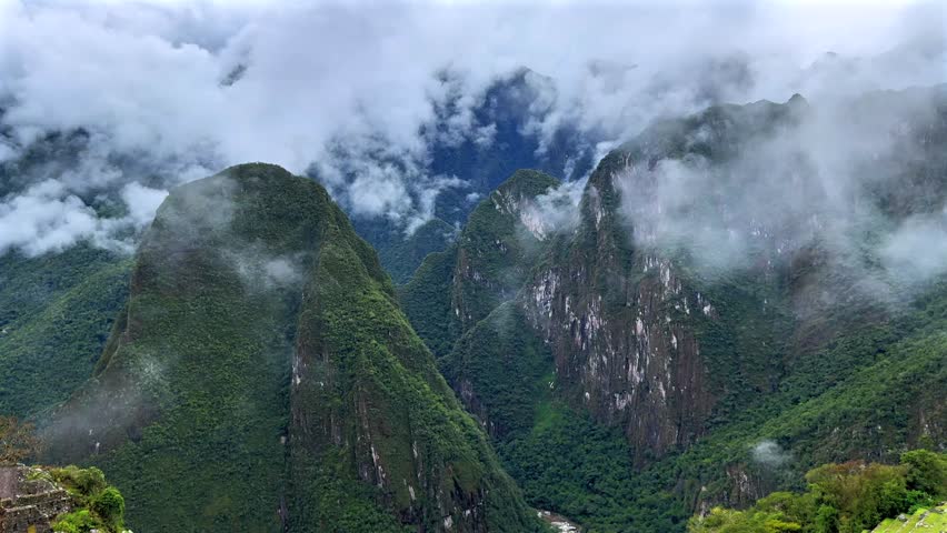 Machu Pichhu Peruvian Andes jungle Aguas Clients Peru Perú aerial drone Shihuahuaco Huayna Picchu gate mountain range morning rising low clouds fog weather rainy season panoramic landscape Inca temple