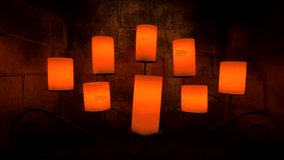 Soft candlelight flickers against a textured wall, creating a warm and cozy ambient atmosphere. Decorative candles glow in a symmetrical arrangement, ideal for relaxation, meditation, romantic settings, or background visuals. - Powered by Shutterstock - Get 15% off with code: PIKWIZARD15