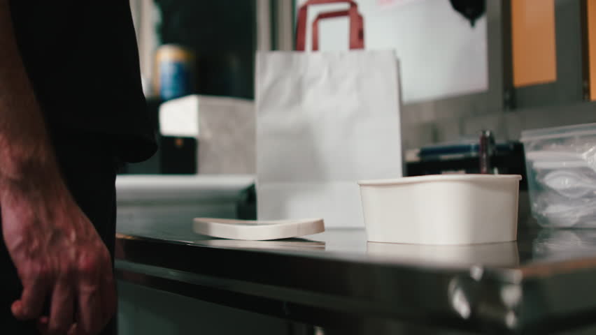 Chef packing takeaway order in restaurant kitchen