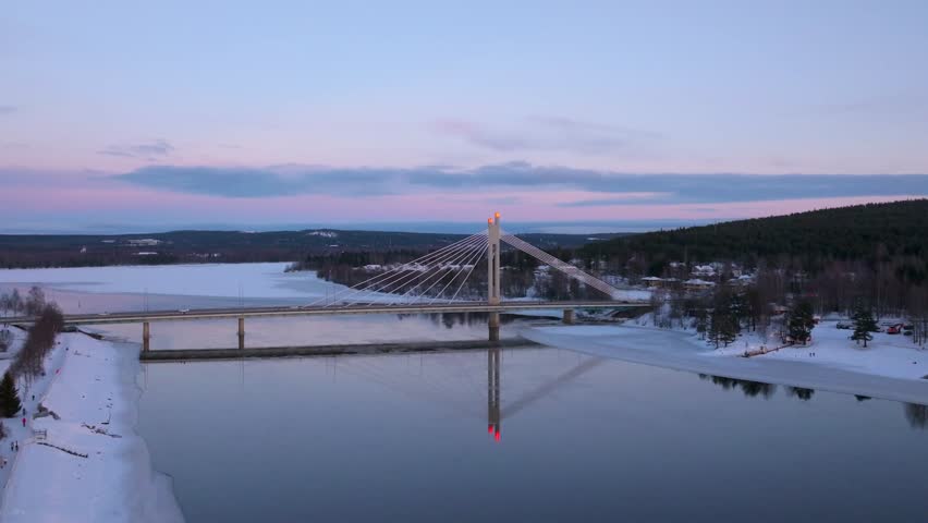 4K cinematic drone footage of Rovaniemi, Finland, captured at golden hour during the winter solstice, showcasing the iconic Jätkänkynttilä (Lumberjack’s Candle) Bridge_52