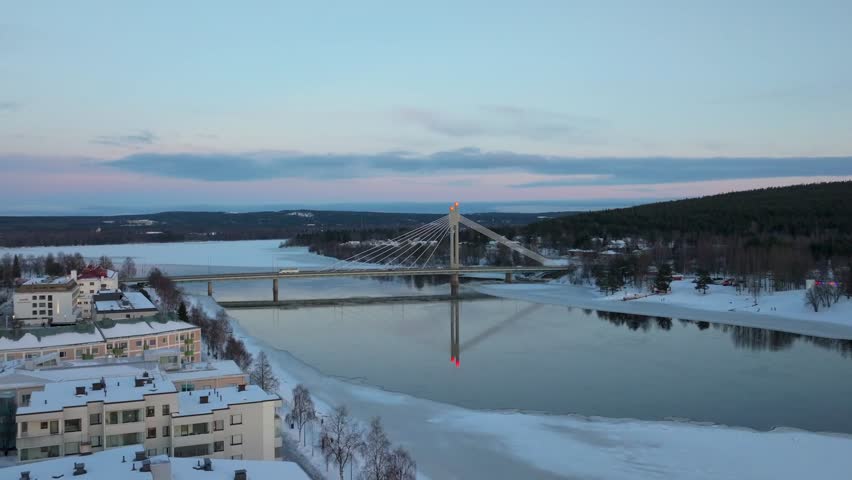 4K cinematic drone footage of Rovaniemi, Finland, captured at golden hour during the winter solstice, showcasing the iconic Jätkänkynttilä (Lumberjack’s Candle) Bridge_51