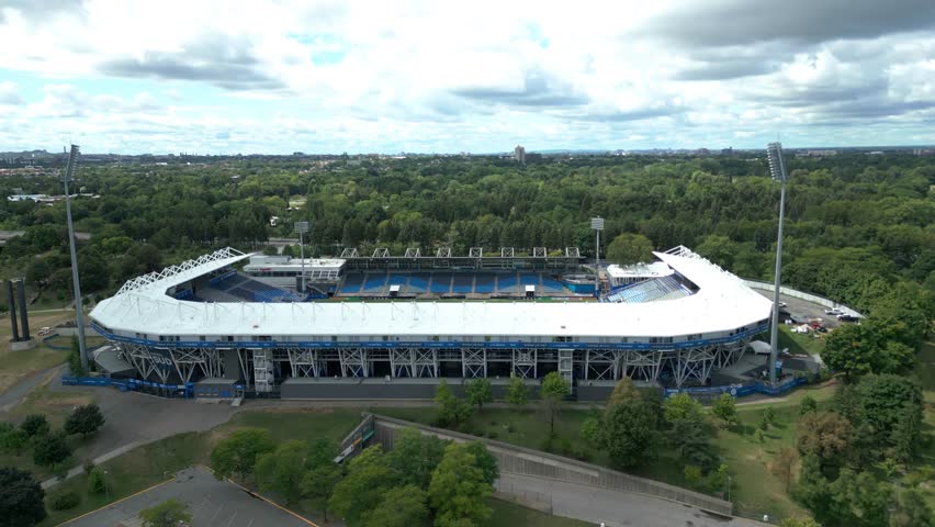 Smooth drone circling Montreal olympic stadium with sleek modern design and surrounding greenery, medium establishing