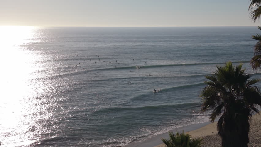 Many surfers in the ocean waiting their turn to surf waves at Swamis in Encinitas, California.