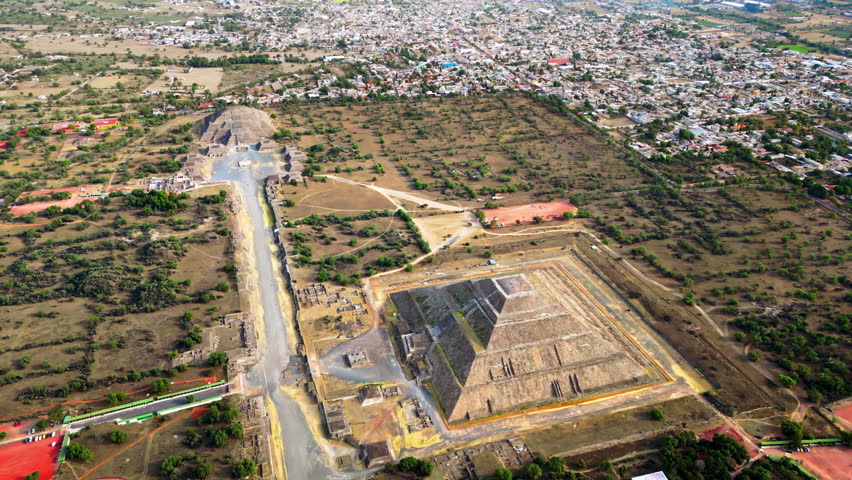 Aerial drone view of the ancient Teotihuacan pyramids with the surrounding Mexican town and mountain landscape
