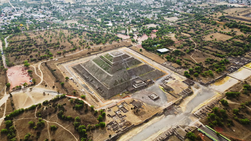 Aerial drone view of the ancient Teotihuacan pyramids with the surrounding Mexican town and mountain landscape