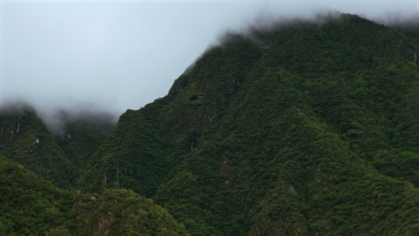 Aguas Calientes Machu Picchu town rainy season cloudy morning Peru aerial drone Peruvian Andes Mountains Urabumba river jungle lower highlands Inca trail citadel landscape static shot