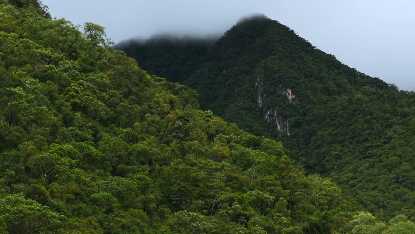 Aguas Calientes Machu Picchu town rainy season cloudy morning Peru aerial drone Peruvian Andes Mountains Urabumba river jungle lower highlands Inca trail citadel landscape parallax circle right pan
