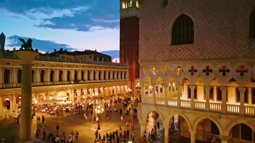 Venice at night with iconic San Marco Tower. San Marco square on dramatic night sky. Venice historic San Marco square aerial view. Venice San Marco at sunset. SanMarco basilica destination in Venezia.