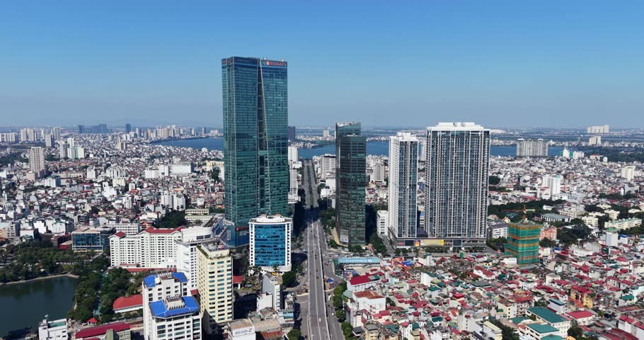 Aerial view of Hanoi’s city lights with tall buildings surrounding a lakes and roads in Vietnam.