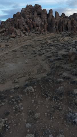 Vertical 4K drone footage flying forward over Alabama Hills, California, revealing rugged boulders, desert terrain, and expansive natural landscapes.