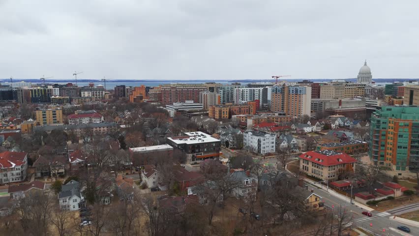 Aerial view of downtown Madison, Wisconsin on a cloudy winter day, featuring city buildings surrounding the State Capitol.