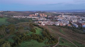 El Carambolo hill, marked by scattered olive trees and unpaved walking trails near town of Camas with its mix of traditional white low-rise buildings and modern brick-toned apartment complexes, Spain. - Powered by Shutterstock - Get 15% off with code: PIKWIZARD15