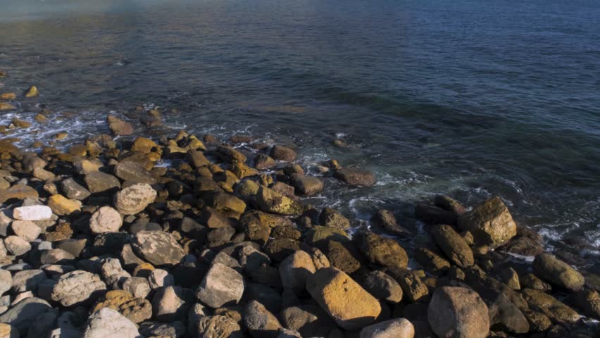 Waves gently reach the Cassis shoreline as the surrounding hills shape the seaside landscape