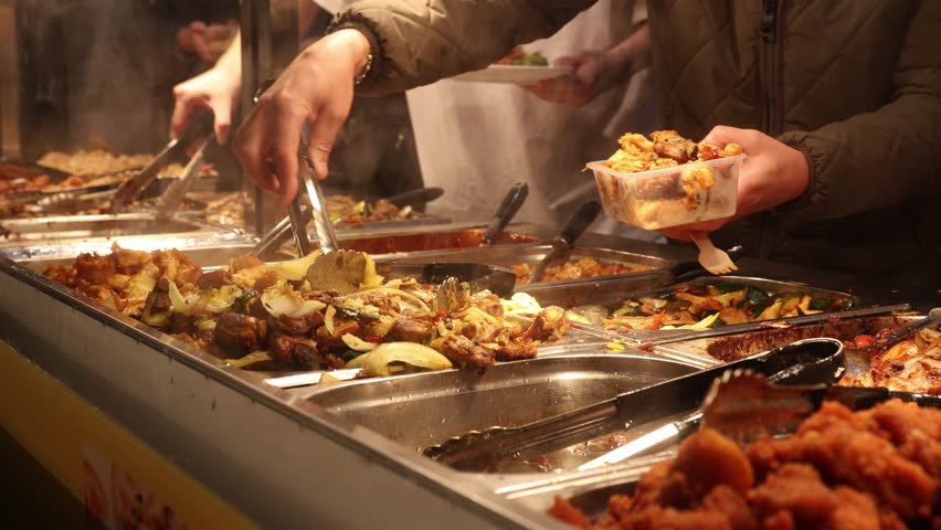 People at Asian buffet taking food in food boxes