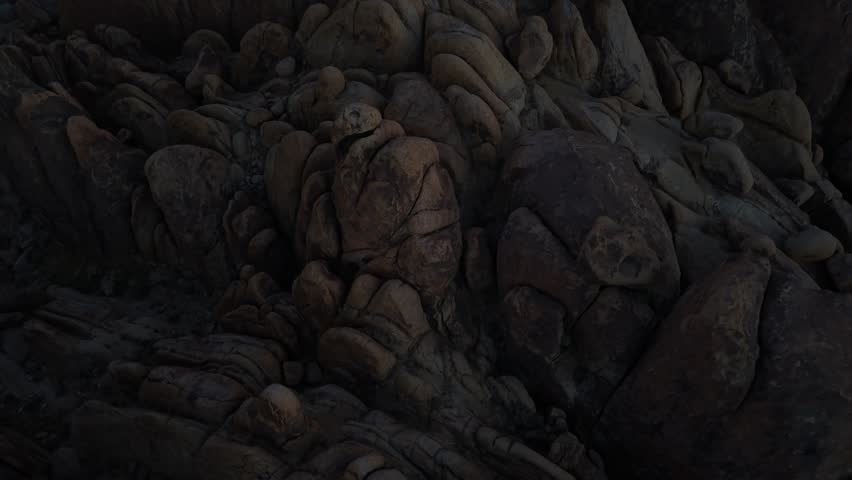 Horizontal 4K real-time drone footage ascending over the boulders of Alabama Hills, California. The clip showcases rugged rock formations, the desert landscape, and expansive natural scenery, highlighting the dramatic beauty and vast wilderness of the Eastern Sierra region.