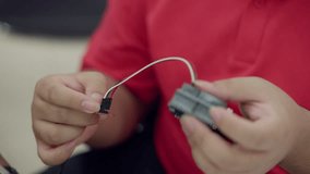 Close-up of student hands connecting jumper wires to an electronic module during a STEM robotics activity for learning coding and circuits. - Powered by Shutterstock - Get 15% off with code: PIKWIZARD15