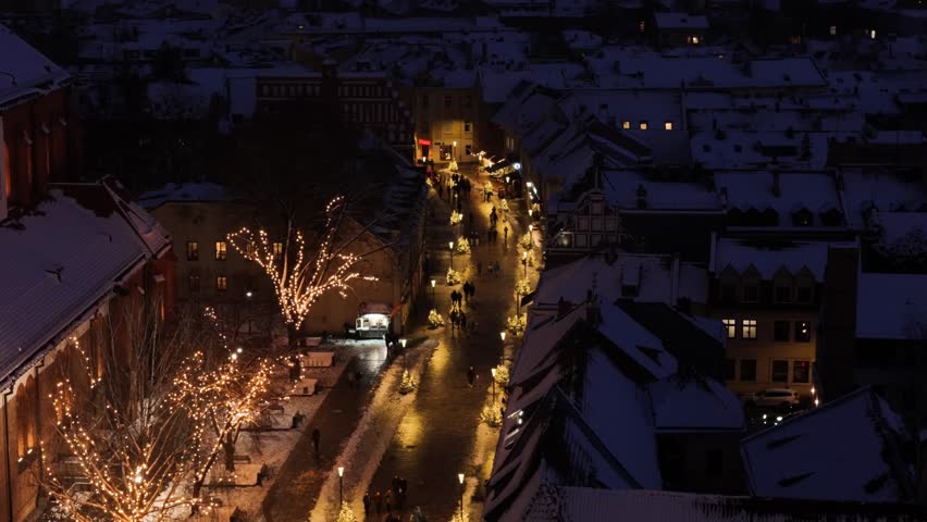 Kaunas Cathedral and old town street decorated with glowing lights at night, aerial view