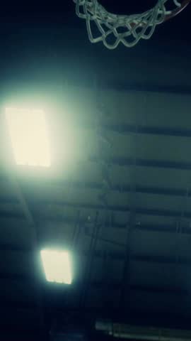 Slow motion of basketball going through the hoop vertical video