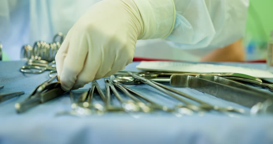 Healthcare professional organizing surgical instruments on sterile table for cleanliness and readiness. Healthcare Professionals Responsible for Handling and Managing Surgical Instruments Effectively