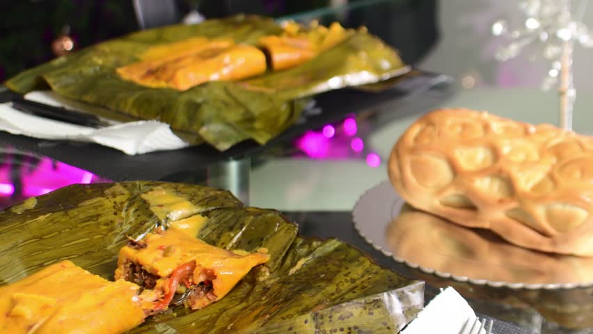 Traditional hallacas and ham bread on a festive table setting