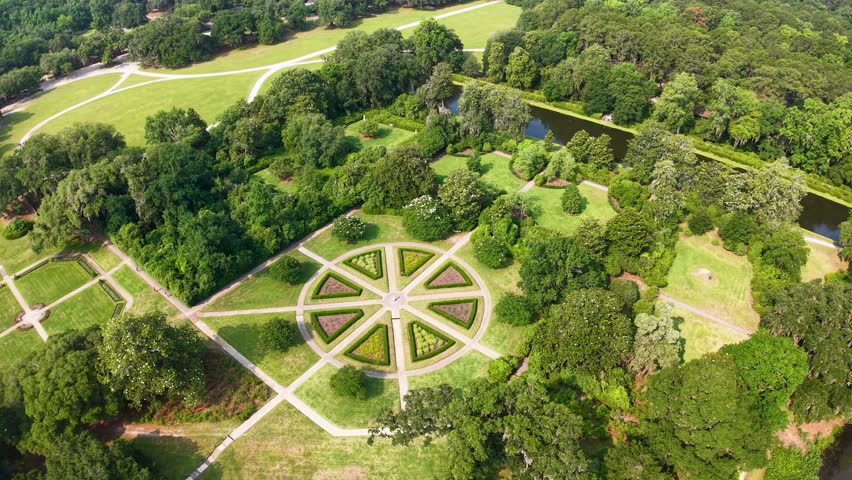 Drone footage captures a large circular plaza with radiating paths surrounded by expansive green lawns in a park in Charleston South Carolina.