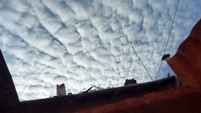 Altocumulus clouds ripple across the sky above rooftops and wires, forming a textured, mid - level blanket - capturing a quiet urban moment with atmospheric depth and visual rhythm - Powered by Shutterstock - Get 15% off with code: PIKWIZARD15