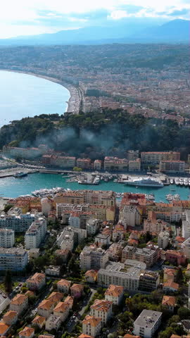 4K aerial vertical video of Nice Port Lympia and Castle Hill park. Cinematic drone footage of Baie des Anges curve and Promenade des Anglais. Iconic French Riviera travel view for mobile reels.