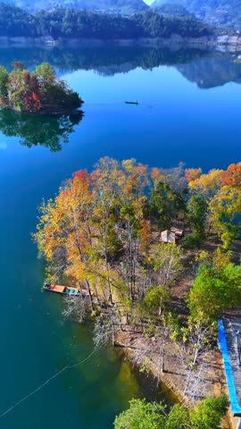 Aerial View of Small Island with Colorful Autumn Trees in Deep Blue Lake