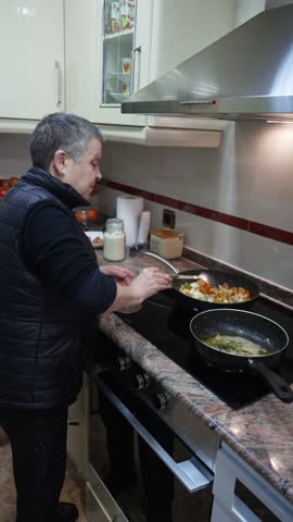 Elderly woman preparing a healthy homemade meal with fresh ingredients on a modern induction stovetop
