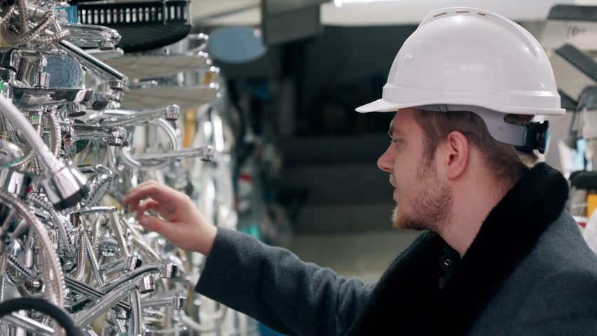 Engineer in a hard hat inspecting goods in a store.