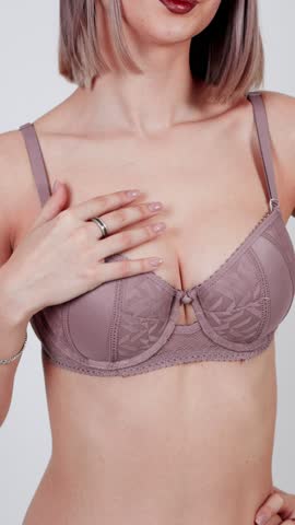 Woman wearing elegant purple lace bra and jewelry.