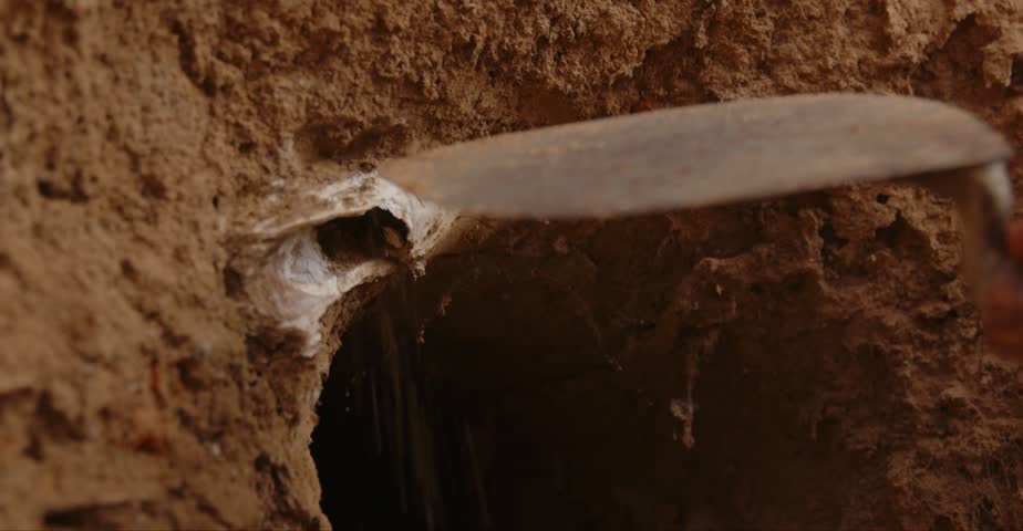 Close-up of Hole in Mud Wall during Archeological Excavation Archaeologist Brushing Soil  