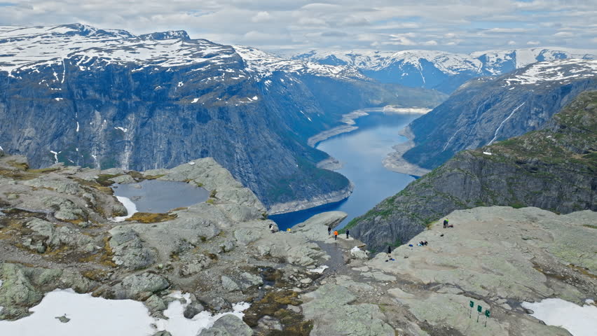 Panoramic view of Ringedalsvatnet fjord from Trolltunga hiking area in Norway. Dramatic cliffs and deep blue water emphasize iconic Nordic scenery.