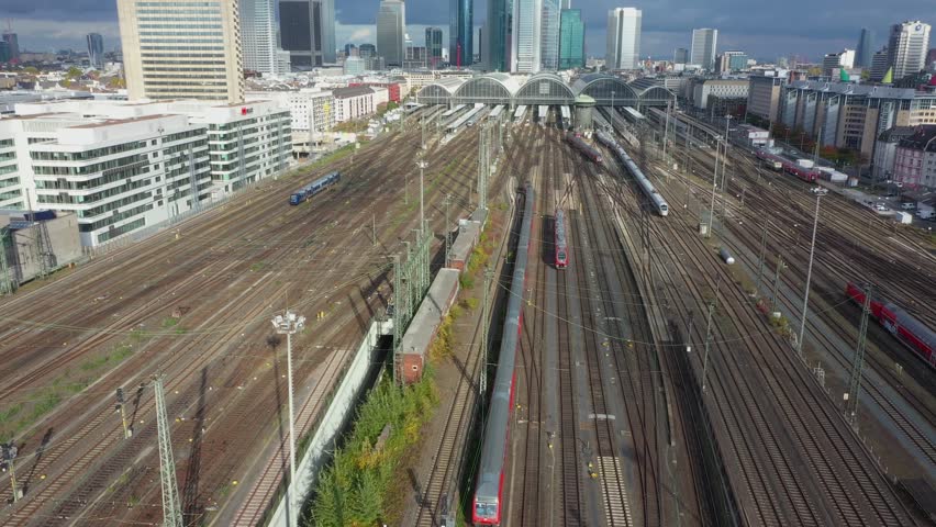 Aerial Forward Drone Flight over Frankfurt am Main, Germany. Central Train Station. Train Tracks with Traffic, High angle view of train station building.