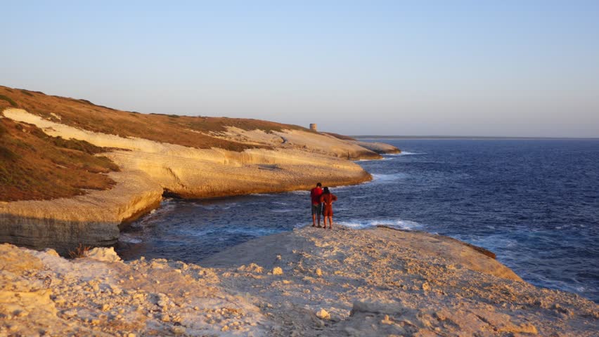 Couple in amazing geological formations of Su Riu and Sa Ide in Sardinia at sunset, Italy