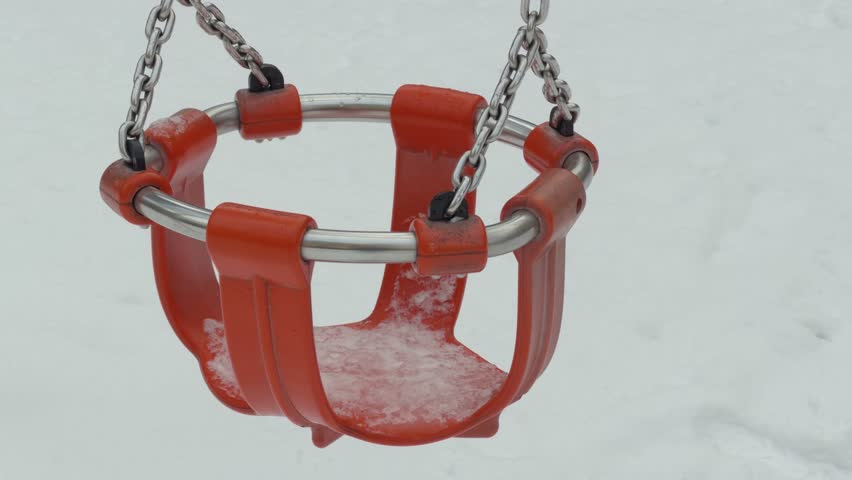  Close up of frozen baby swing at Playground in winter. Berlin.