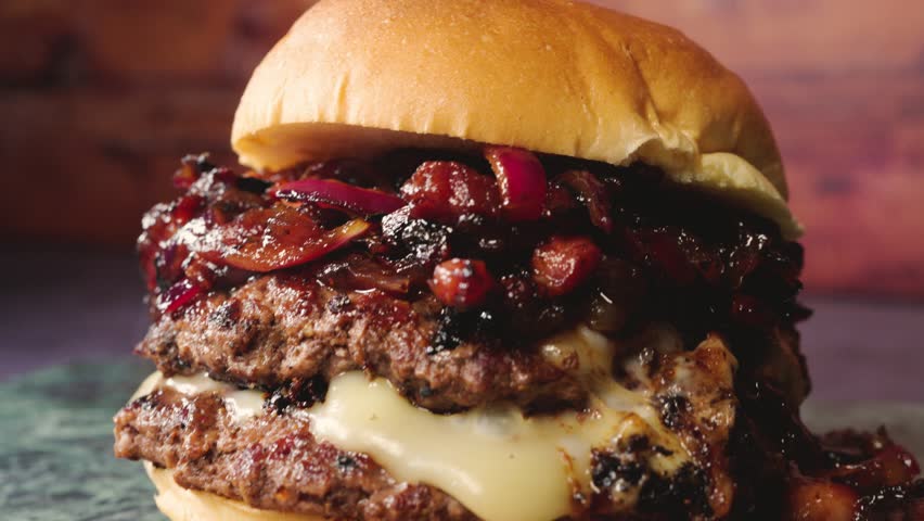 Delicious burger topped with sweet-savory bacon jam, red onion, and melted cheese. Beautifully presented, juicy, and full of flavor. Perfect for gourmet burger lovers and food photography.