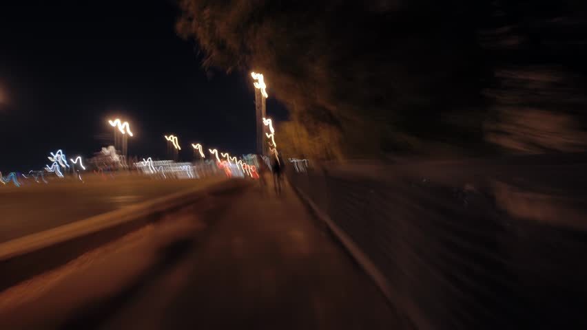 City sidewalk at night with motion blurred people walking, urban life speed blur