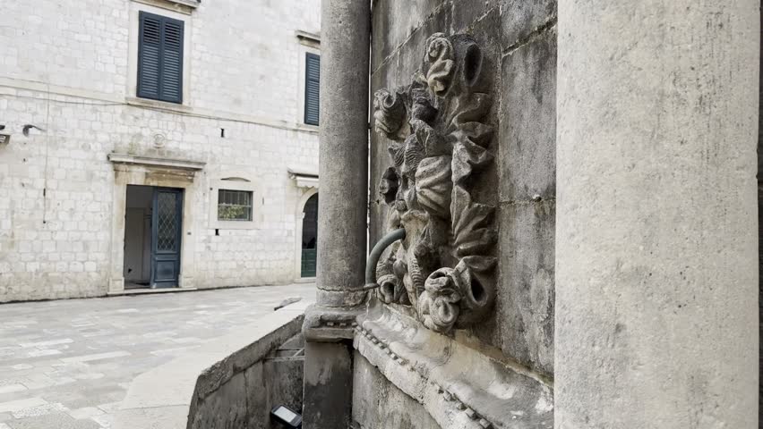 Close-up of a masceron and water pouring from iconic limestone marvel Onofrio