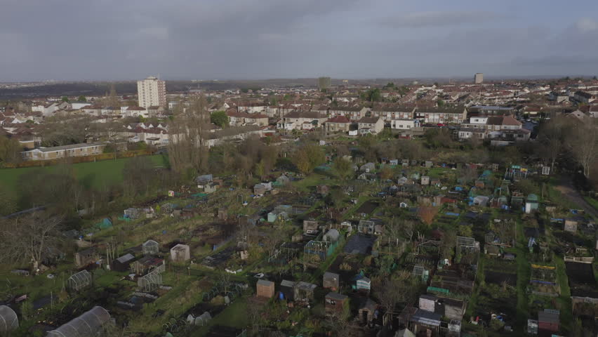 Aerial tilting down to urban allotment plots and vegetable patches in the UK