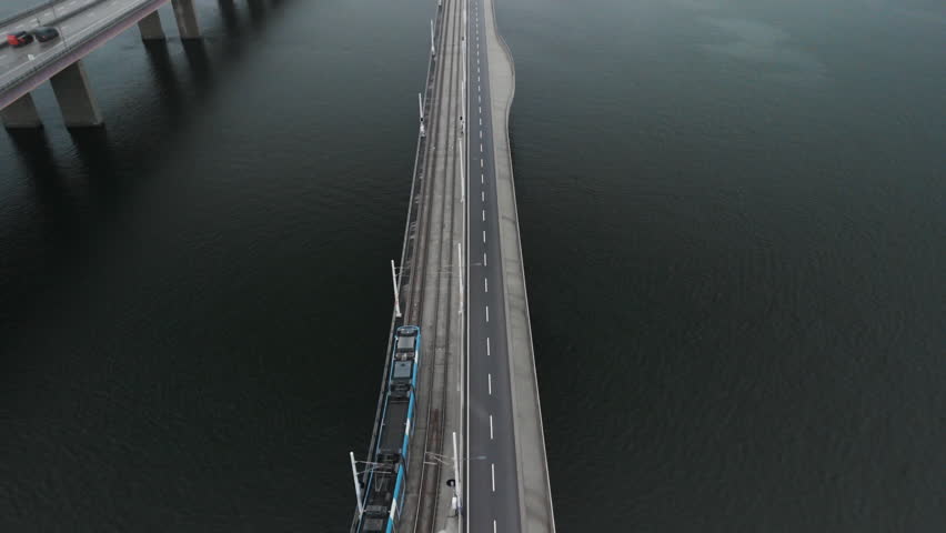 Drone shot of a tram on a small bridge