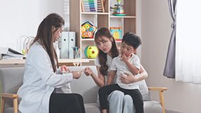 Professional Asian female dentist holding a realistic dental teeth model and a toothbrush, demonstrating and teaching proper oral hygiene and tooth brushing techniques to a young Asian boy and his mother. The scene is set in a bright, modern, and friendly dental clinic or home-like environment, creating a warm and educational atmosphere. The dentist is smiling and engaging with the family, while the mother and son look on with interest. This high-quality stock photo represents pediatric dentistry, healthcare education, preventative dental care, and professional medical consultation for families. Perfect for use in dental clinic marketing, healthcare articles, parenting blogs, and medical educational materials. The image features natural lighting and a clean, lifestyle aesthetic that appeals to modern healthcare themes - Powered by Shutterstock - Get 15% off with code: PIKWIZARD15
