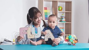 Cheerful Asian female doctor or pediatrician smiling at the camera while holding a cute baby boy and displaying colorful alphabet props that spell the word FLU A. The background features a bright and friendly pediatric clinic setting with educational toys, abacus, and shelves. This image effectively highlights flu vaccine awareness, pediatric healthcare, child immunization, and preventative medicine during flu season. The doctor friendly expression creates a sense of trust and care, making it ideal for medical healthcare marketing, flu prevention campaigns, pediatric clinic websites, and medical blog content related to child wellness and vaccination programs - Powered by Shutterstock - Get 15% off with code: PIKWIZARD15