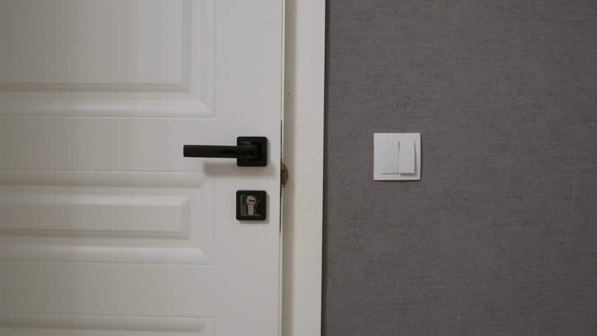 Young Asian girl in pink pajamas carrying a green basket full of clothes for washing. Domestic chores, childhood independence and everyday family life in a cozy home environment.